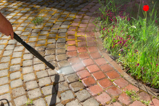 professional power washer washing dirty pavers